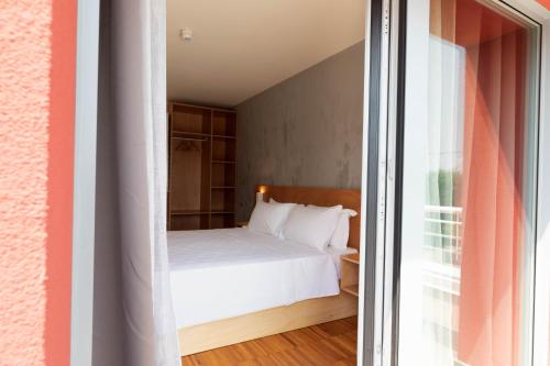 a bedroom with a white bed and a window at Torre Antica Venice Airport Hotel in Tessera