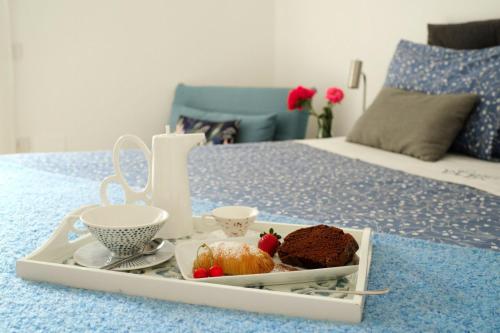 bandeja con un pastel y un set de té en una cama en DANLÚ, en Salerno