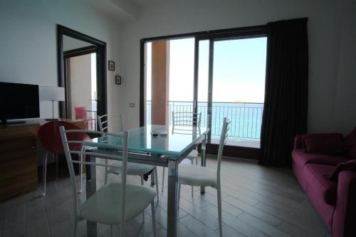 a dining room with a table and chairs and a couch at Nuraghe Apartments in Teulada