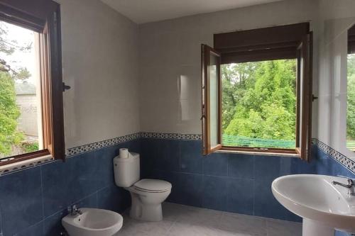 a bathroom with a toilet and a sink and a window at Casa acogedora en Celorio in Llanes