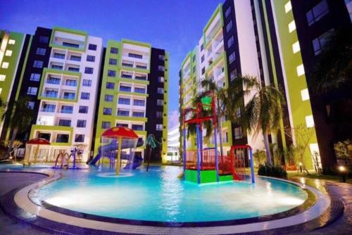 a large pool with a playground in front of some buildings at Ipoh Manhattan TSL Pool View Water Park Homestay! in Kampong Pinji