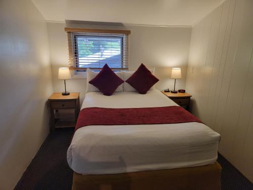 a bedroom with a large bed with two tables and two lamps at St Moritz Lodge and Condominiums in Aspen