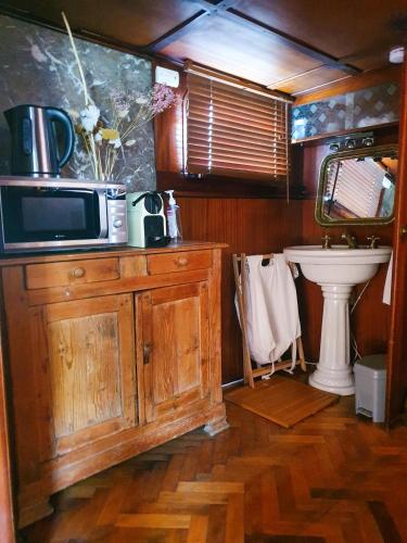 - une cuisine avec un four micro-ondes au-dessus d'une armoire en bois dans l'établissement Bateau péniche Lille - Euratechnologie, à Lille