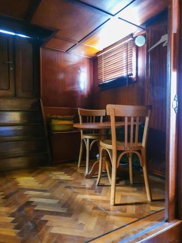 une salle à manger avec une table et des chaises en bois dans l'établissement Bateau péniche Lille - Euratechnologie, à Lille