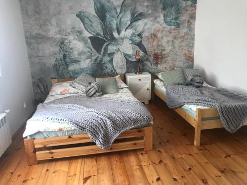 Lekarty的住宿－Zielone Sioło，一间卧室配有两张床和壁画