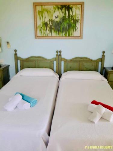 two beds in a room with towels on them at Villa Can Pere Cala Galdana Menorca in Cala Galdana