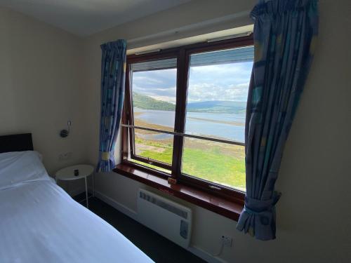 a bedroom with a window with a view of the water at Waterfront Lodge - Accommodation Only in Fort William