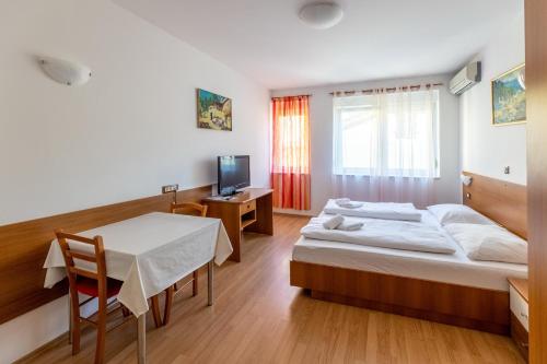 a hotel room with a bed and a table at Apartments Liburnija in Opatija