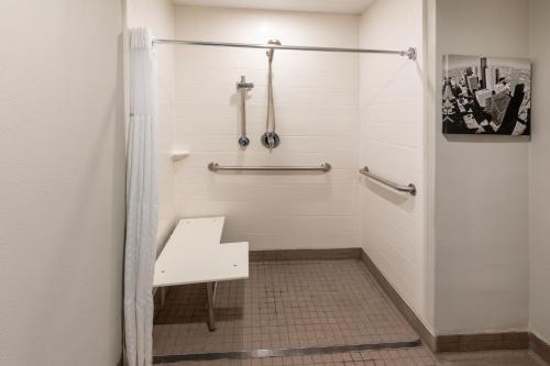 a bathroom with a shower with a bench in it at La Quinta by Wyndham Houston NW Brookhollow in Houston