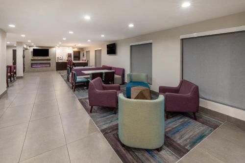 a waiting room with purple chairs and a chalkboard at La Quinta by Wyndham Houston NW Brookhollow in Houston