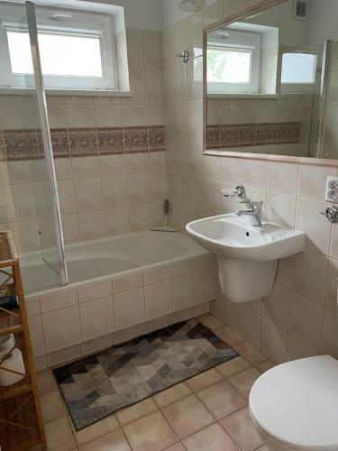 ein Badezimmer mit Badewanne, Waschbecken und Toilette in der Unterkunft Lansada in Zabór