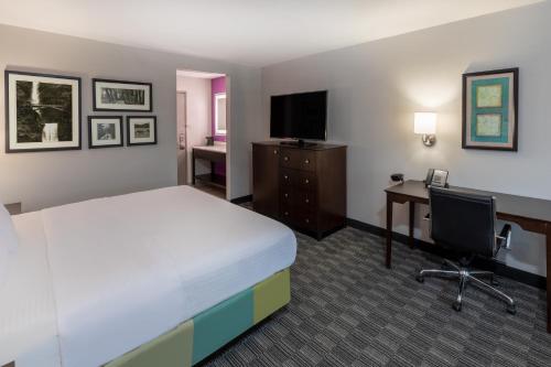 a hotel room with a bed and a desk and a computer at La Quinta by Wyndham Houston NW Brookhollow in Houston
