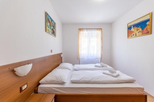 1 dormitorio con 2 camas y ventana en Apartments Liburnija en Opatija