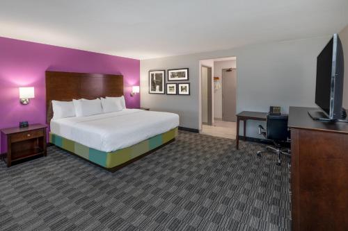 a bedroom with a bed and a desk and a tv at La Quinta by Wyndham Houston NW Brookhollow in Houston