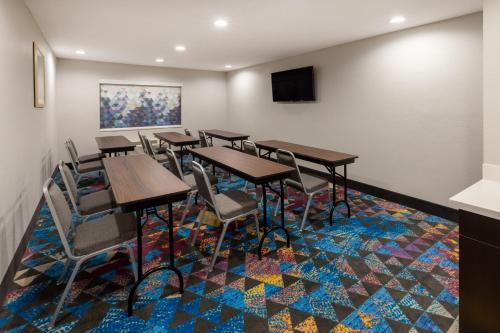a room with tables and chairs on a colorful carpet at La Quinta by Wyndham Houston NW Brookhollow in Houston
