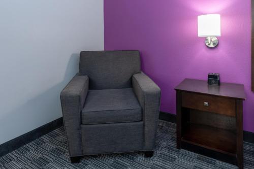 a chair in a room with a table and a lamp at La Quinta by Wyndham Houston NW Brookhollow in Houston