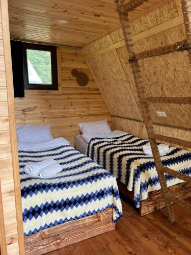 two beds in a log cabin with a window at GLAMPING WOLF MOUNt in Margahovit