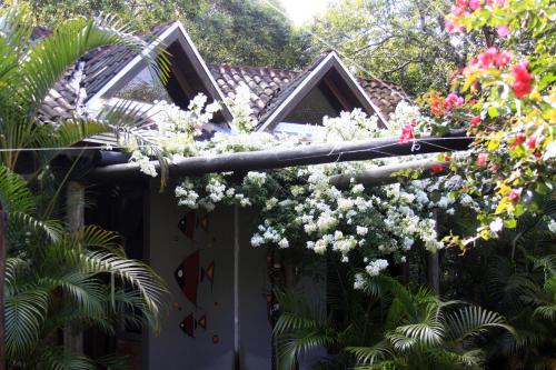 a house with a bunch of flowers on a pole at Vila da Pousadinha in Ilha do Mel