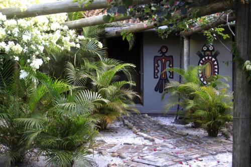 a front door of a house with trees and plants at Vila da Pousadinha in Ilha do Mel