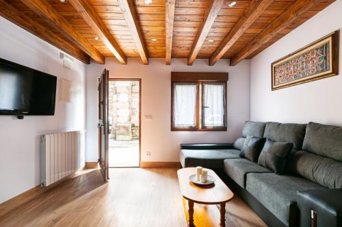 a living room with a couch and a table at La casita de susa en mazcuerras in Villanueva de la Peña