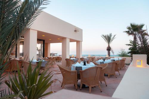 a restaurant on the beach with tables and chairs at Vincci Dar Midoun in Djerba