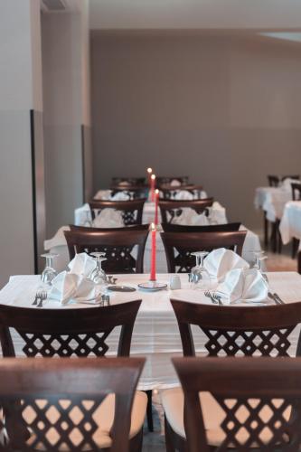 a row of tables with chairs and a candle on them at Vincci Dar Midoun in Djerba