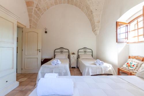 a bedroom with two beds with white sheets at Le Dimore Di Speziale in Fasano