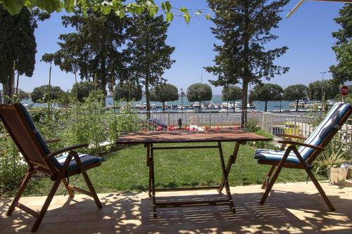 a picnic table and two chairs on a patio at Apartment Derossi in Umag