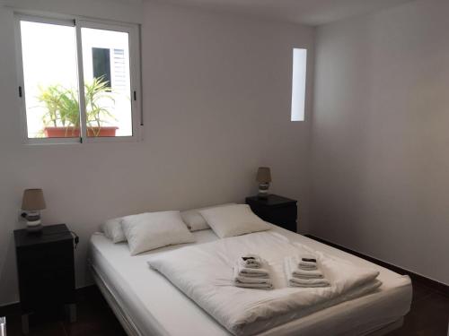 a bedroom with a white bed with two towels on it at Casa Cosy in Valencia