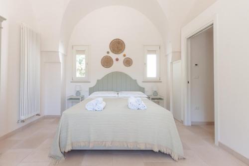 a white bedroom with a bed with towels on it at Le Dimore Di Speziale in Fasano
