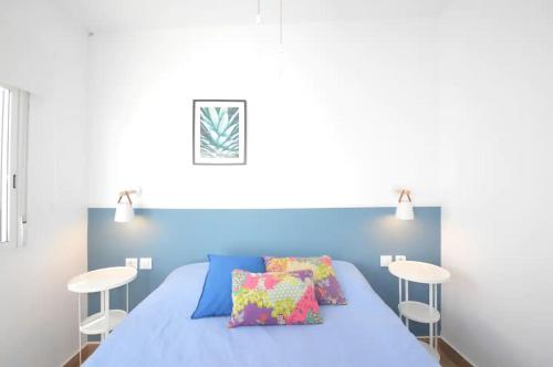 a bedroom with a blue bed with two stools at Apartamentos ALAZUL JRJ in Conil de la Frontera