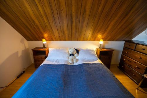 a teddy bear laying on a bed in a bedroom at Heidi Guesthouse in Selfoss