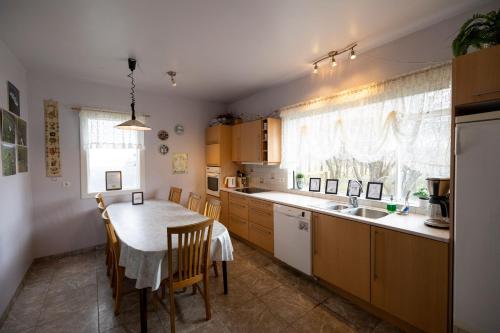 a kitchen with a table and chairs and a sink at Heidi Guesthouse in Selfoss