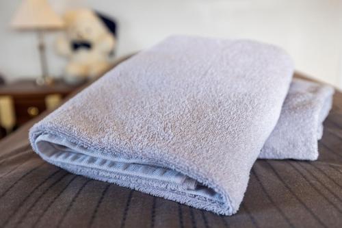 a pile of towels sitting on top of a bed at Heidi Guesthouse in Selfoss
