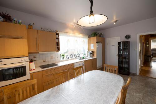 a kitchen with wooden cabinets and a dining table at Heidi Guesthouse in Selfoss