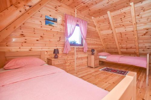 a bedroom with two beds in a log cabin at Big bear villas in Žabljak