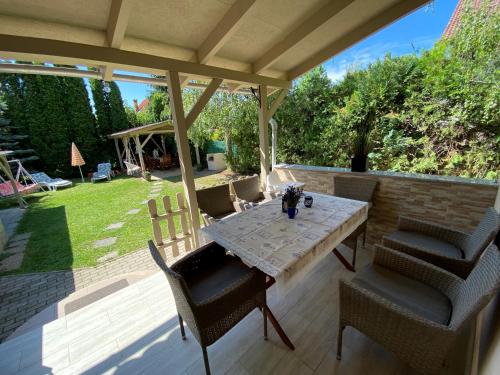 a patio with a table and chairs on a patio at Sommer Ferienhaus in Balatonszárszó