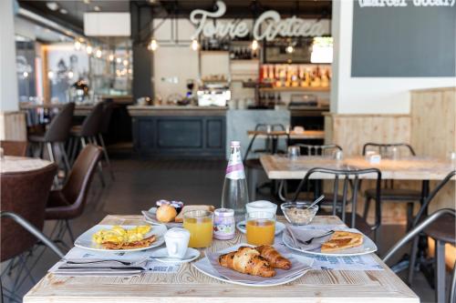 a table topped with plates of food and orange juice at Torre Antica Venice Airport Hotel in Tessera