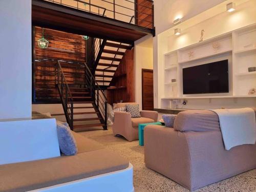 Il comprend un salon avec des canapés et une télévision à écran plat. dans l'établissement Yemaya Villa Curaçao Unique-Oceanfront-Private stairway to sea!, à Willemstad