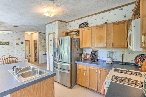 a kitchen with wooden cabinets and a stainless steel refrigerator at Bright Steinhatchee Home Proximity to Ocean! in Steinhatchee