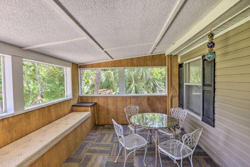 a screened in porch with a table and chairs at Bright Steinhatchee Home Proximity to Ocean! in Steinhatchee