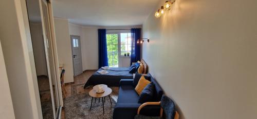 a living room with a blue couch and a table at Apartament Hexagon nr 21 in Grzybowo