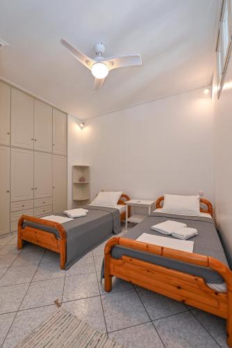 a bedroom with two beds and a ceiling fan at Teresa's Sunrise in Panormos