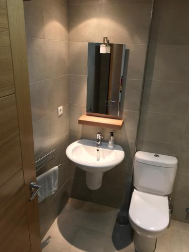 a bathroom with a white toilet and a sink at Apartamento Olmeca in Santander