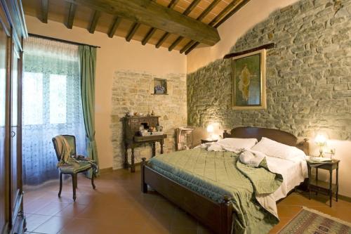 een slaapkamer met een bed en een stenen muur bij Agriturismo Petrognano in SantʼEllero