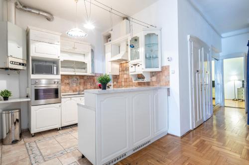 una cucina con armadietti bianchi e pavimenti in legno di Huge Apartment in the city center a Budapest