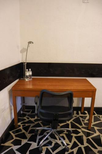 a desk with a chair and a lamp on a rug at Hotel Vitorina Cholula in Cholula