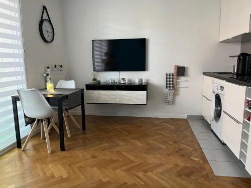 Superbe studio lumineux haut de gamme tout confort في درانسي: مطبخ مع طاولة وتلفزيون على جدار