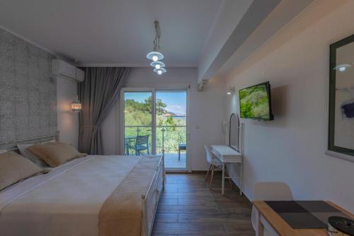 a bedroom with a bed and a desk and a window at Olive Garden Villas and Apartments in Chrysi Ammoudia