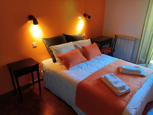 a bedroom with a large bed with orange walls at Quinta de Leandres in Manteigas